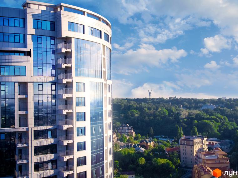 Житловий комплекс Busov Hill - сучасна новобудова з панорамним склінням та балконами, що відкриває вид на зелені пагорби та місто.