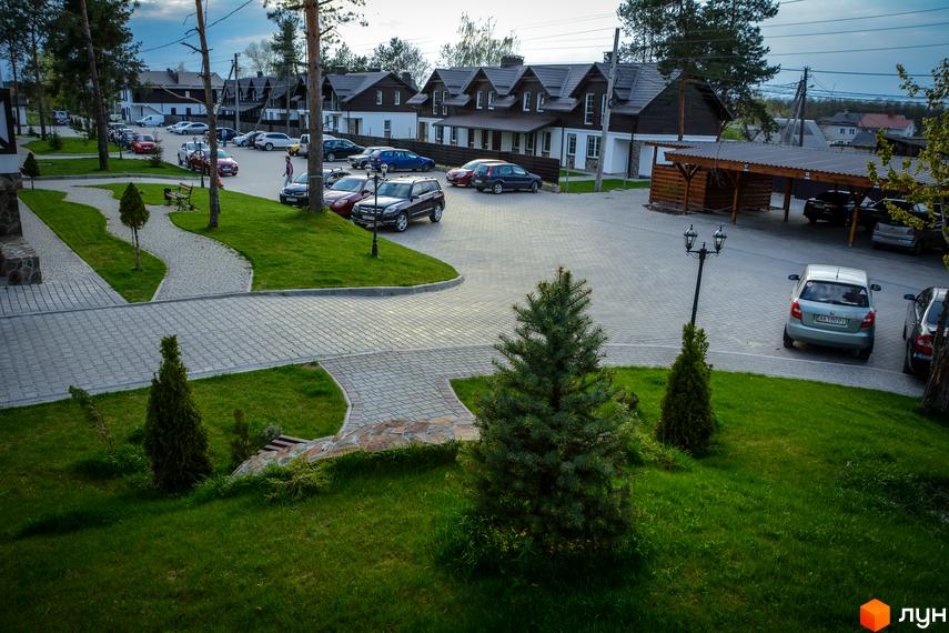 Таунхаус Desna Residence з акуратною прибудинковою територією, парковкою та зеленими насадженнями. Зовнішній вигляд будівель та облаштований двір.