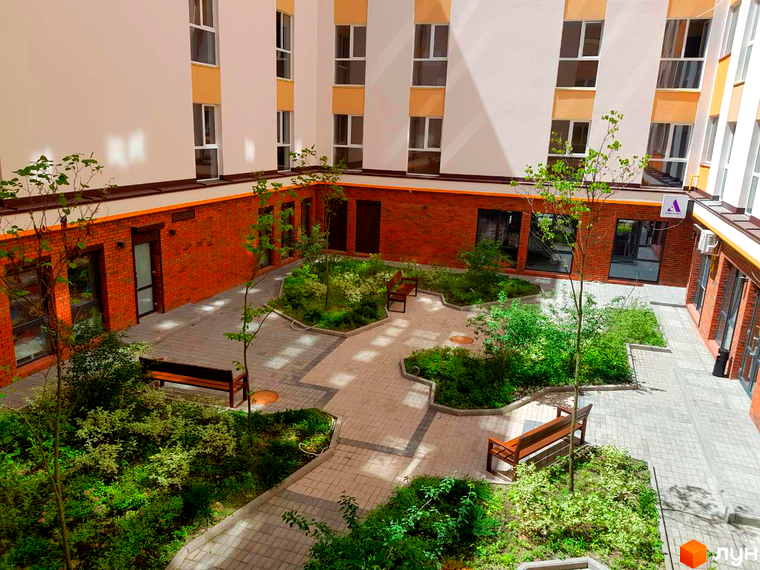 Клубний будинок Fort House - це сучасний житловий комплекс з цегляним фасадом та затишним внутрішнім двором з зеленими насадженнями та лавками.