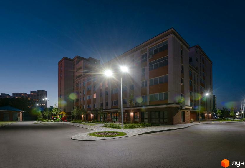 Зображення фасаду будинку Клубний будинок Fort House ввечері. Навколо будинку облаштована прибудинкова територія з освітленням.