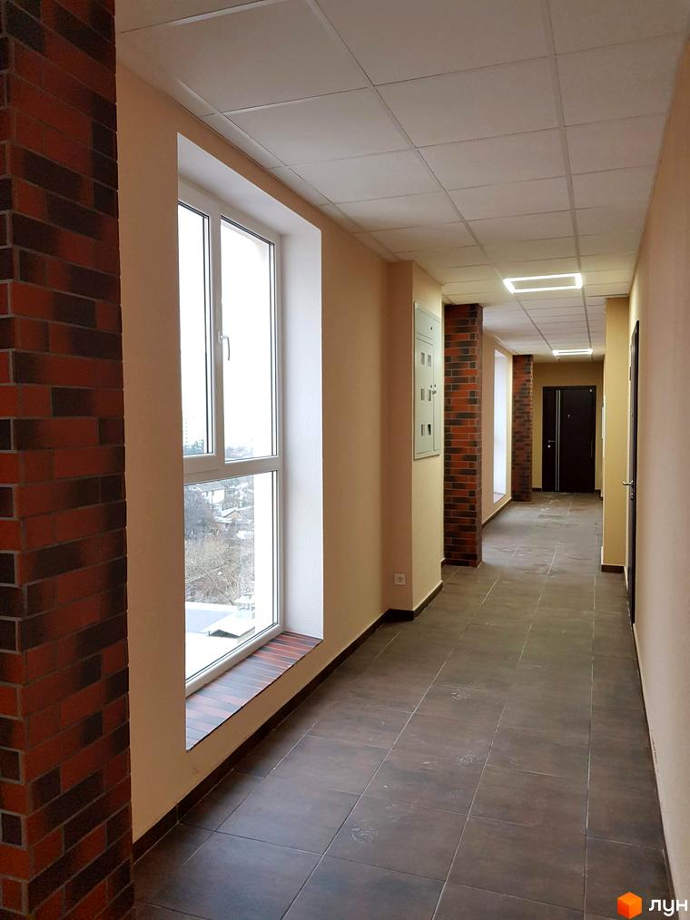 Фото коридору в Клубний будинок Fort House. Інтер'єр з цегляними колонами, великим вікном та плиткою на підлозі.