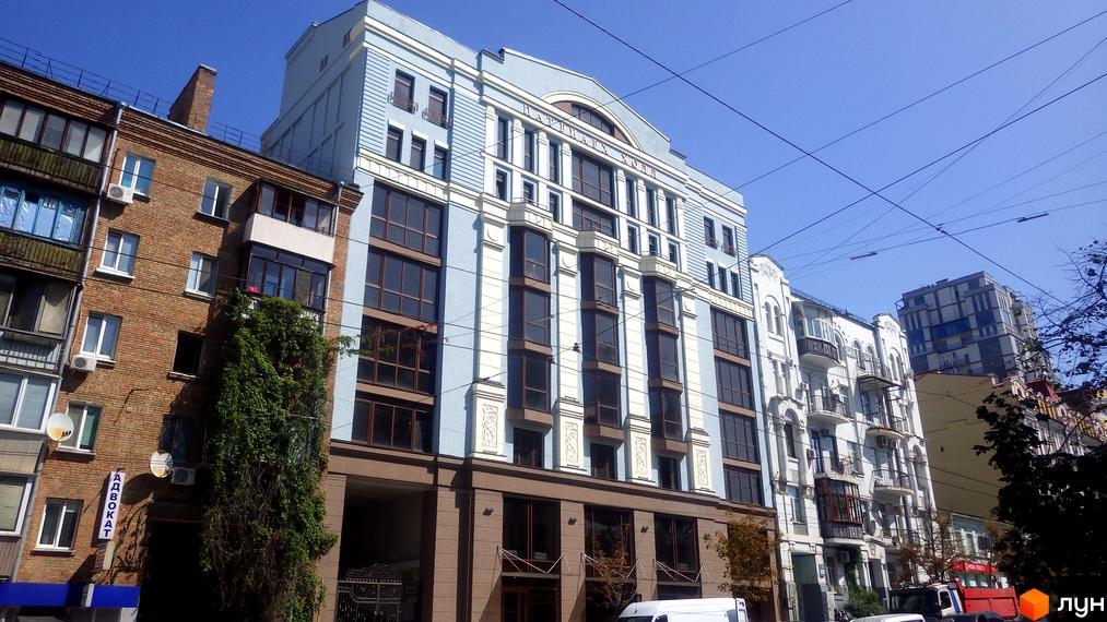 Клубний будинок „Патріарх Холл“ з блакитним фасадом та великими вікнами. Навколо будинку розташовані інші будівлі та зелені насадження.