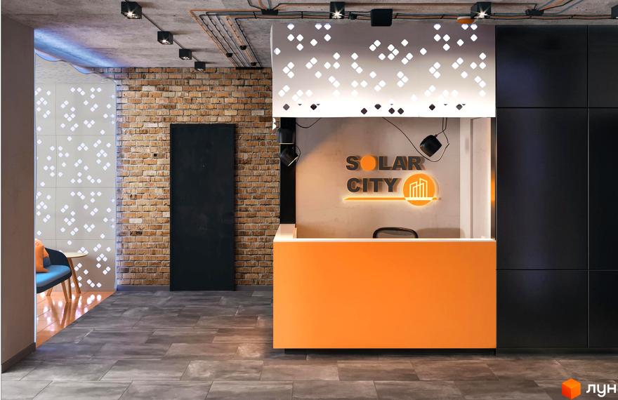 Інтер'єр офісу ЖК Solar City. Яскравий дизайн з помаранчевою стійкою ресепшн та логотипом. Цегляна кладка та чорні панелі створюють контраст.