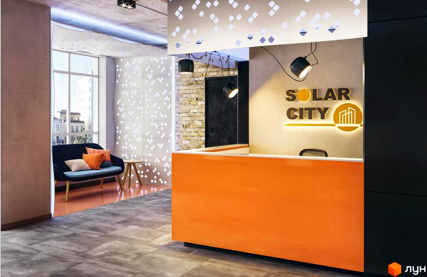 Яскравий інтер'єр вхідної зони ЖК SOLAR CITY з помаранчевою стійкою ресепшн та логотипом. На задньому плані видно зону відпочинку з диваном та вікном.