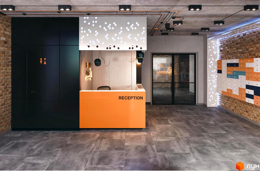 Інтер'єр холу в ЖК SOLAR CITY. Стіни з цегли та декоративними елементами, помаранчева стійка рецепції з написом «RECEPTION».
