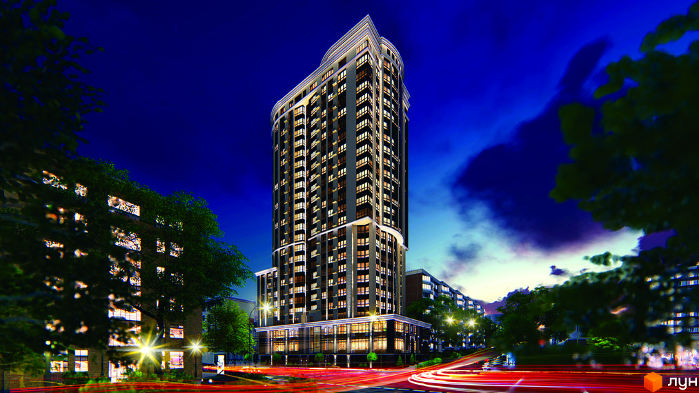 Висотна будівля житлового комплексу Володимирський ввечері. Фасад будинку з великою кількістю вікон, освітленням та прилеглою територією.