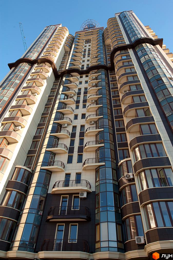 Високий Житловий комплекс Престиж Холл з багатосекційним фасадом, що поєднує скляні елементи та округлі балкони.