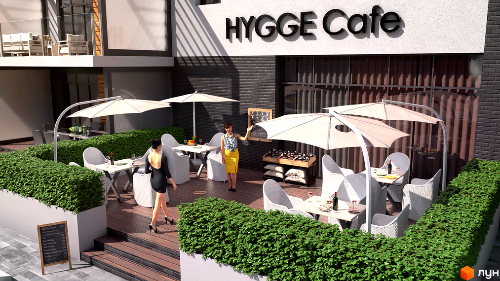 Фасад Котеджного містечка Hygge Home з балконом та терасою кафе. Тераса облаштована білими меблями, парасолями та зеленими насадженнями.