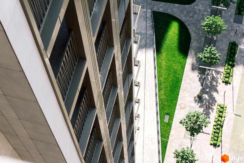 Вигляд фасаду та прибудинкової території Житлового комплексу New York Concept House. Багатоповерхівка з балконами та зелена зона з деревами.