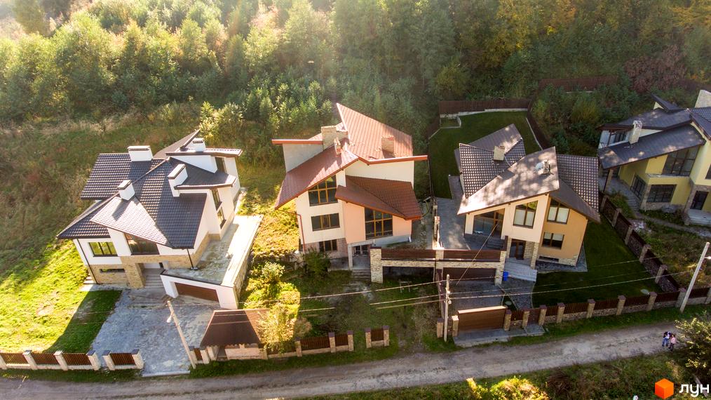 Котеджне містечко Буковий Гай: сучасні будинки з коричневими дахами та великими вікнами, доглянута прибудинкова територія з газоном та огорожею.
