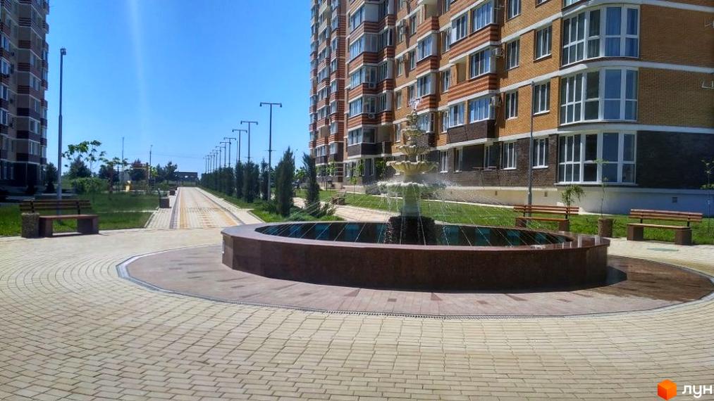 Житловий комплекс Цветной бульвар (Чорноморськ) з багатоповерховими будинками та фонтаном на прибудинковій території. Сучасний житловий район з ландшафтним дизайном та місцями для відпочинку.
