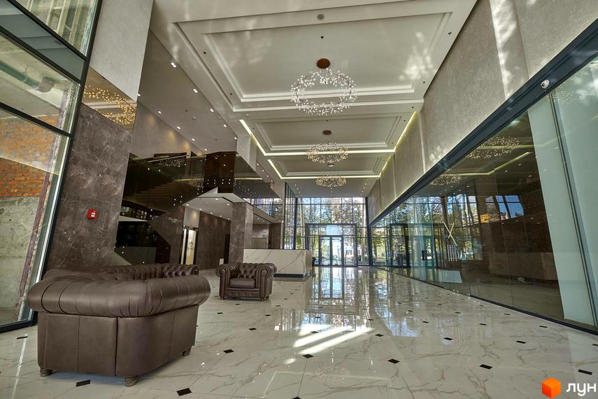 Внутрішній вигляд житлового комплексу Park Avenue VIP з сучасними меблями та великими вікнами. Простора зона з мармуровою підлогою та освітленням.