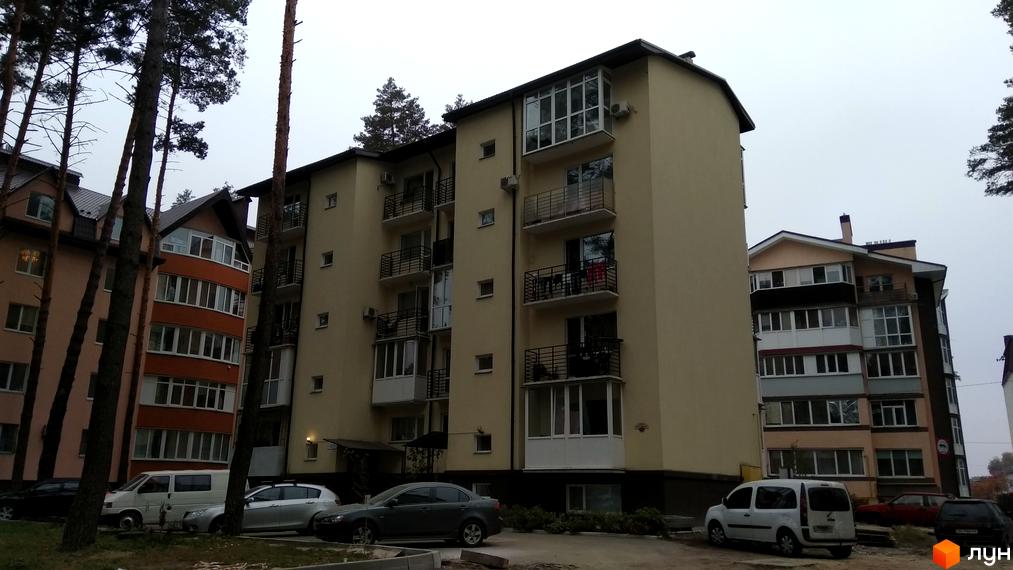 Клубний будинок „10-а лінія“ – це багатоповерхова новобудова з балконами та кондиціонерами. Перед будинком розташована прибудинкова територія з деревами та автомобілями.