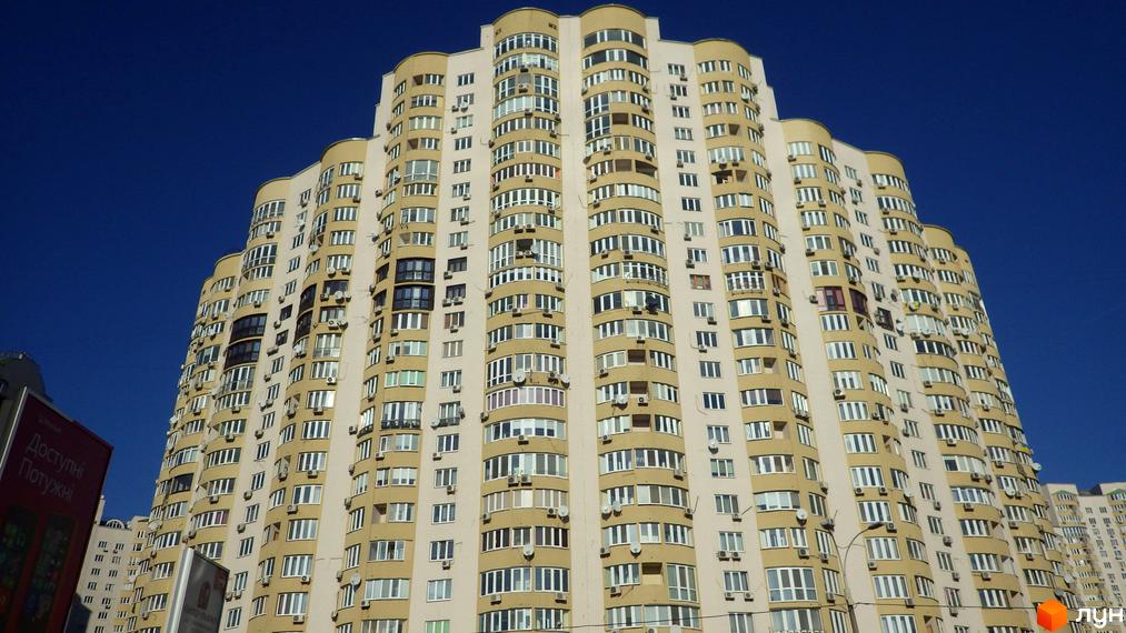 Житловий комплекс на вул. Дніпровська набережна, 19, 19а, 19в, 23, 25. Вид на фасад будинку з великою кількістю вікон та прибудинковою територією.