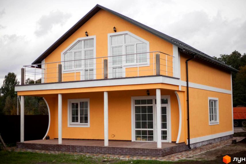 Котеджне містечко Княжичі Хаус. Двоповерховий будинок з помаранчевим фасадом, балконом та терасою, розташований на доглянутій ділянці.