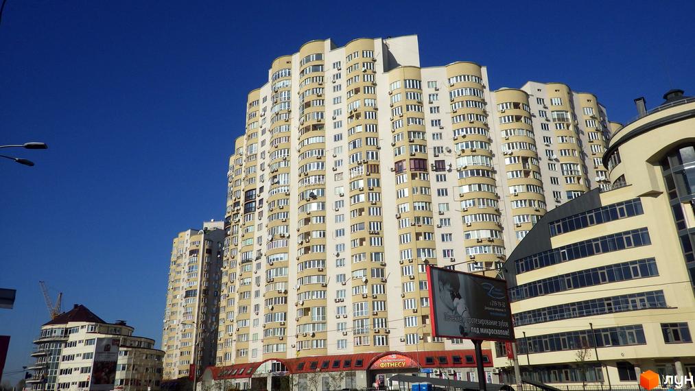 Житловий комплекс на вул. Дніпровська набережна, 19, 19а, 19в, 23, 25. Вид на фасад будинку з великою прибудинковою територією.