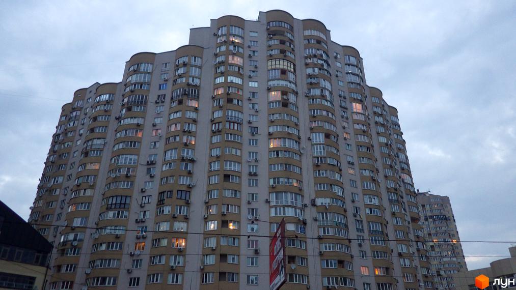 Житловий комплекс на вул. Дніпровська набережна, 19 з фасадом з балконами та вікнами. Прибудинкова територія з елементами благоустрою.