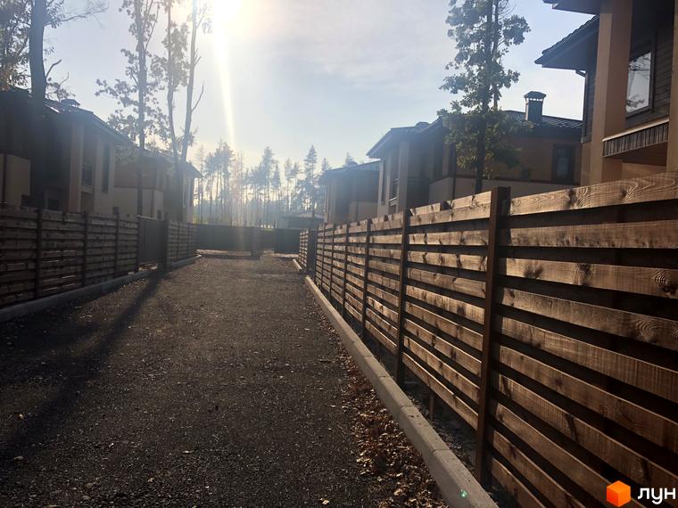 Котеджне містечко КМ Віта Паркова. Зовнішній вигляд будинків та дерев'яний паркан на території комплексу.