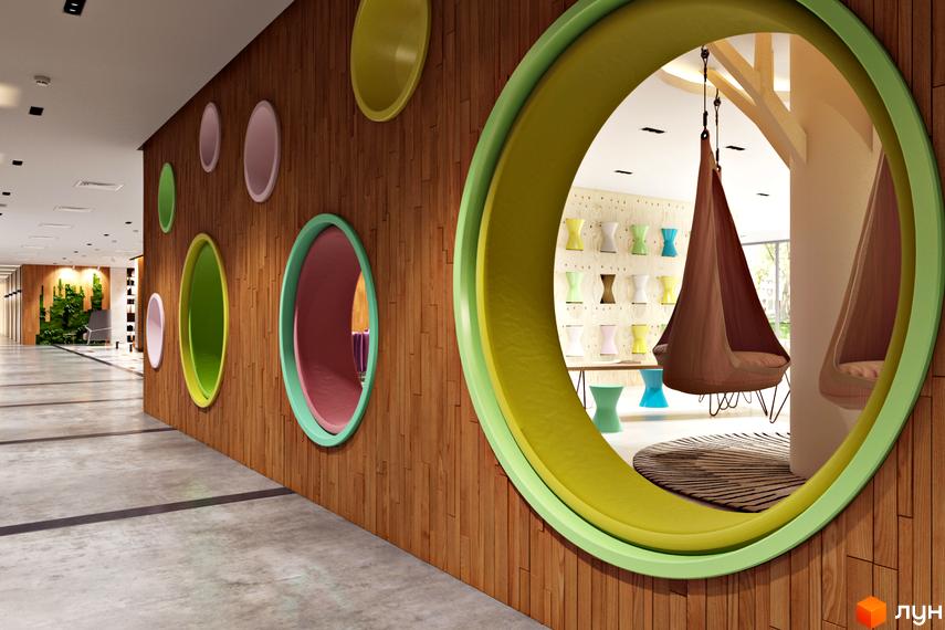 Інтер'єр дитячої зони в ЖК Edelweiss House з круглими отворами та підвісними кріслами. Дитяча кімната з яскравими елементами та місцями для відпочинку.