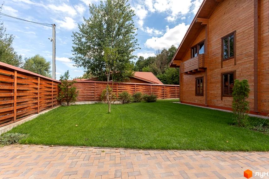 Котеджне містечко Summerville: дерев'яний будинок з великими вікнами та зеленою галявиною перед ним. Огороджена територія з парканом та деревами.