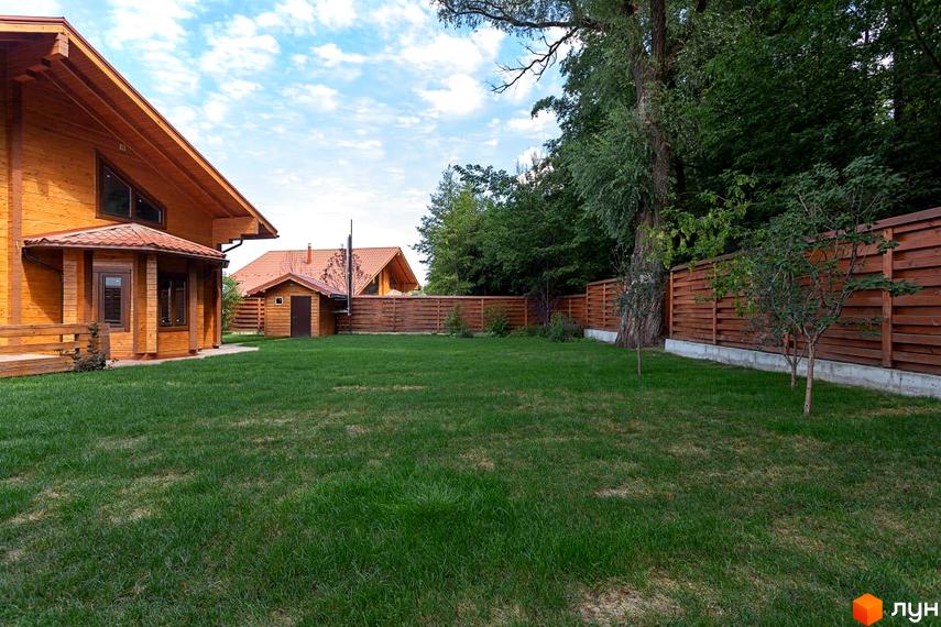 Котеджне містечко Summerville: двоповерховий дерев'яний будинок з червоним дахом та зеленою галявиною перед ним. Огороджена територія з парканом.