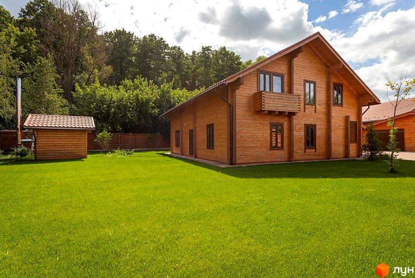 Котеджне містечко Summerville: двоповерховий дерев'яний будинок з балконом та акуратний газон перед ним. Поруч розташована невелика господарська споруда.