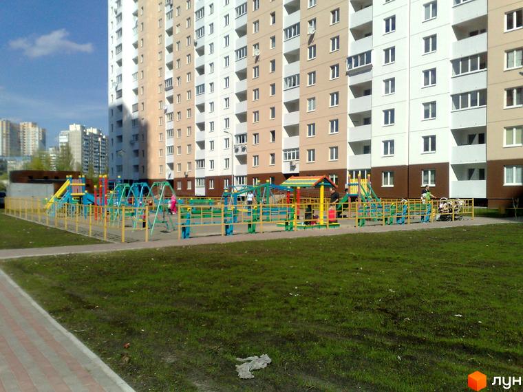 Житловий комплекс вул. Урлівська, 38, будинок з багатоповерховими секціями та дитячим майданчиком на прибудинковій території.