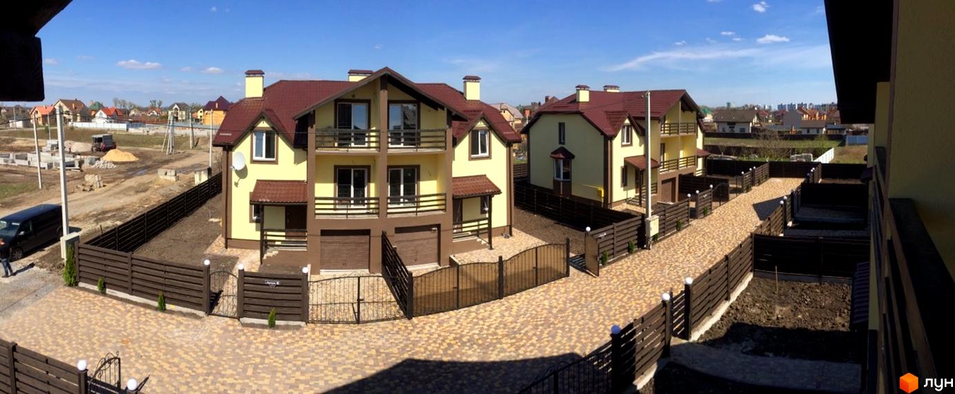 Житловий комплекс Cottage Residence: жовті двоповерхові дуплекси з коричневими дахами та балконами, вимощені бруківкою дворики з дерев'яними парканами.