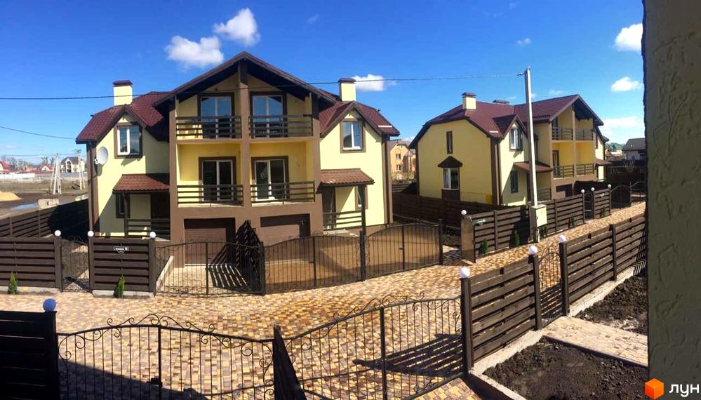 Житловий комплекс Cottage Residence: двоповерхові жовті дуплекси з коричневими дахами та балконами. Прибудинкова територія з дерев'яними парканами та бруківкою.