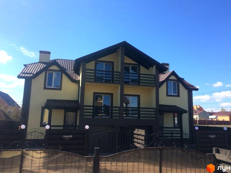 Дуплекси Cottage Residence – двоповерхові будинки світло-жовтого кольору з темними дахами та балконами. Огороджена територія з кованими елементами та парканом.