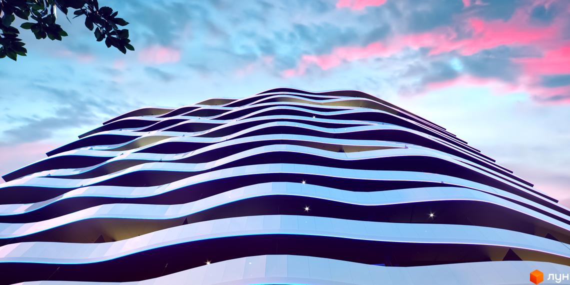 Aura Apart - житловий комплекс з хвилястим фасадом та балконами, що нагадують морські хвилі. Навколо будівлі видно зелене листя та хмарне небо з рожевими відтінками.