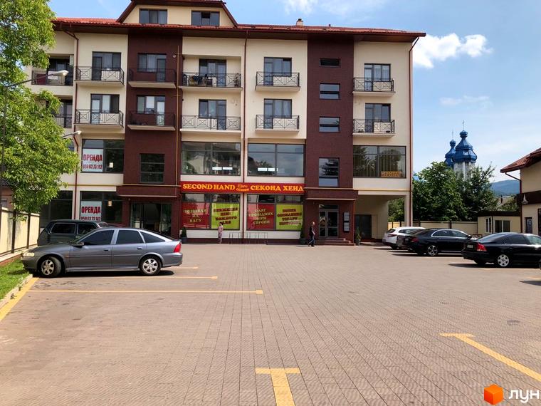 Житловий комплекс Arena Centr – це багатоповерхова будівля з балконами та парковкою перед фасадом.