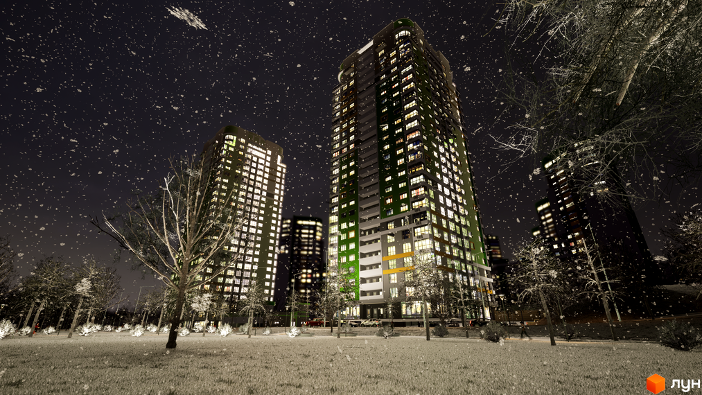 Житловий комплекс Паркове місто вночі під снігопадом. Високі будинки з освітленими вікнами оточені засніженими деревами та газонами.