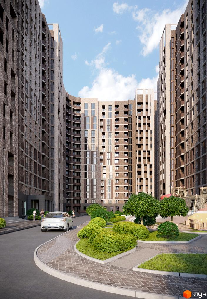 Прохоровський квартал: фасади будинків з цегляним оздобленням та балконами, упорядкована прибудинкова територія з кущами та деревами.