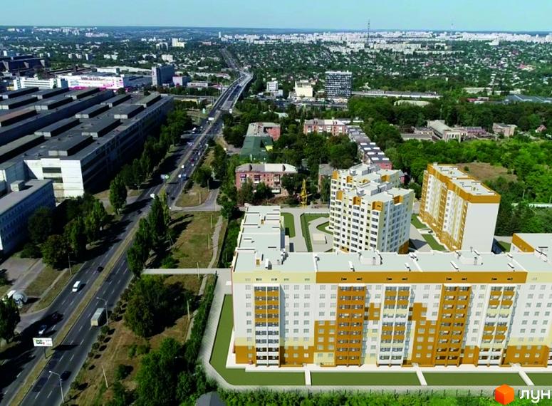 Житловий комплекс Райдужний з багатоповерховими будинками світлого кольору із золотистими акцентами. Навколо розташовані дороги та зелені насадження.