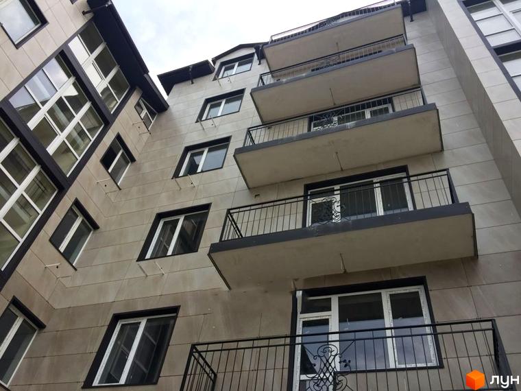 Фасад житлового комплексу Лондон з балконами та вікнами. Зовнішній вигляд новобудови.