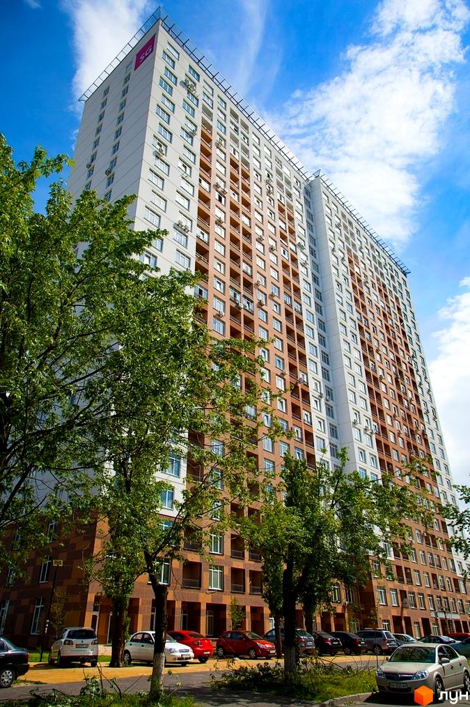 Новобудова на вулиці Ованеса Туманяна, 3, з багатоповерховим будинком біло-коричневого кольору. Прибудинкова територія має зелені дерева та припарковані автомобілі.