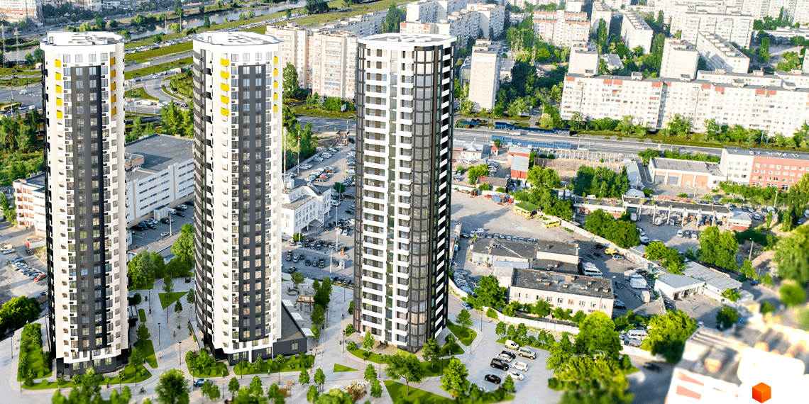 Вид на три висотні новобудови ЖК Райдужний з сірими та білими фасадами та жовтими вставками. Навколо зелена територія з деревами та доріжками.