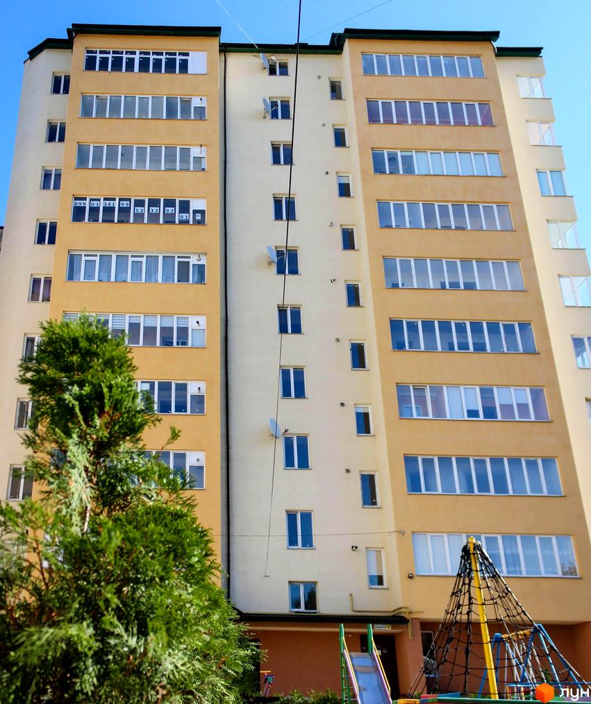 Зовнішній вигляд багатоповерхового будинку по вулиці Надрічна, 2, 2а. На території є дитячий майданчик та зелені насадження.