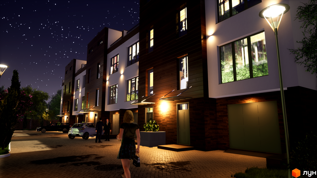 Нічний вигляд таунхаусів Sunny Village з підсвіченими вікнами та фасадом. На прибудинковій території розташовані автомобілі та освітлення.