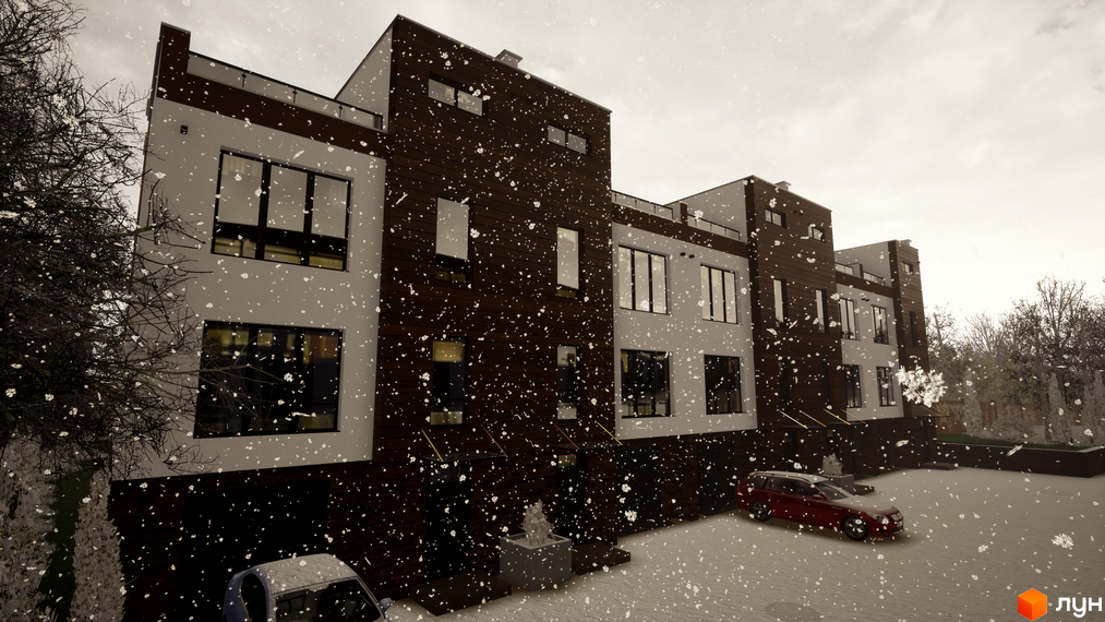 Таунхауси Sunny Village з темним та світлим фасадом під час снігопаду. На прибудинковій території припарковані автомобілі.