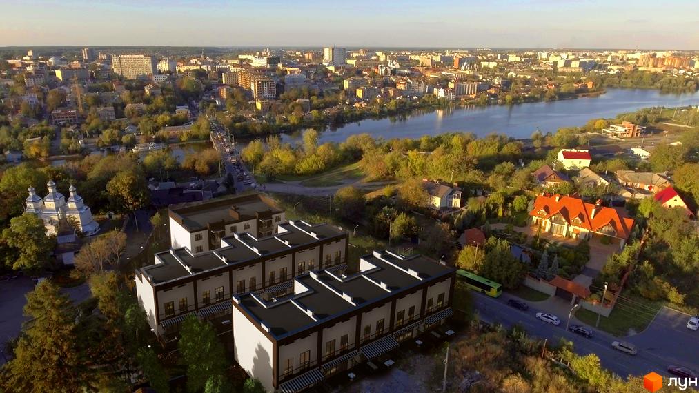 Таунхауси Sunny Village – сучасна забудова з акуратними фасадами та зеленими ділянками. На фото видно прибудинкову територію з деревами та дорогою.