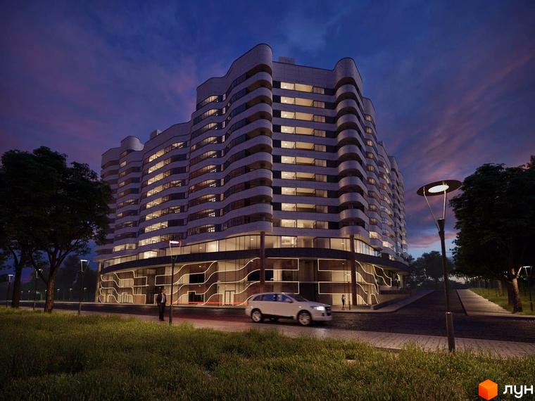 Зображення багатоквартирного будинку на вулиці Степана Бандери. Фасад будівлі з балконами та великими вікнами, освітлений вночі.