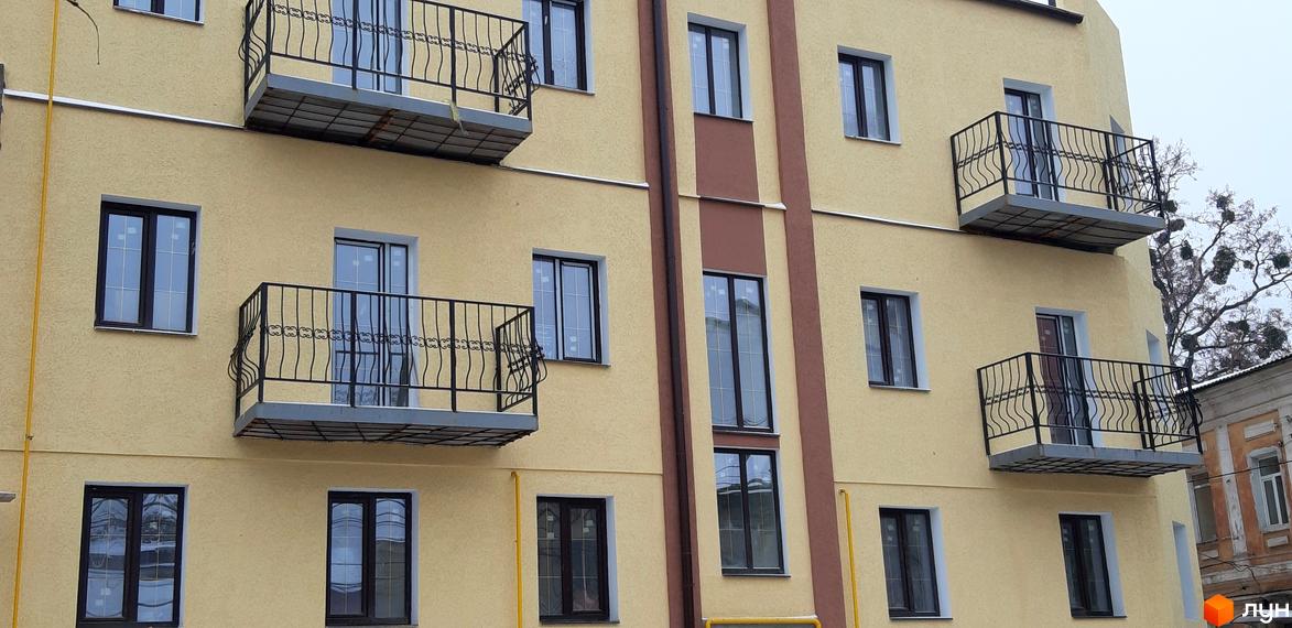 Зовнішній вигляд багатоповерхового будинку ЖК Короховський з балконами та вікнами. Фасад будівлі виконаний у світлих тонах.