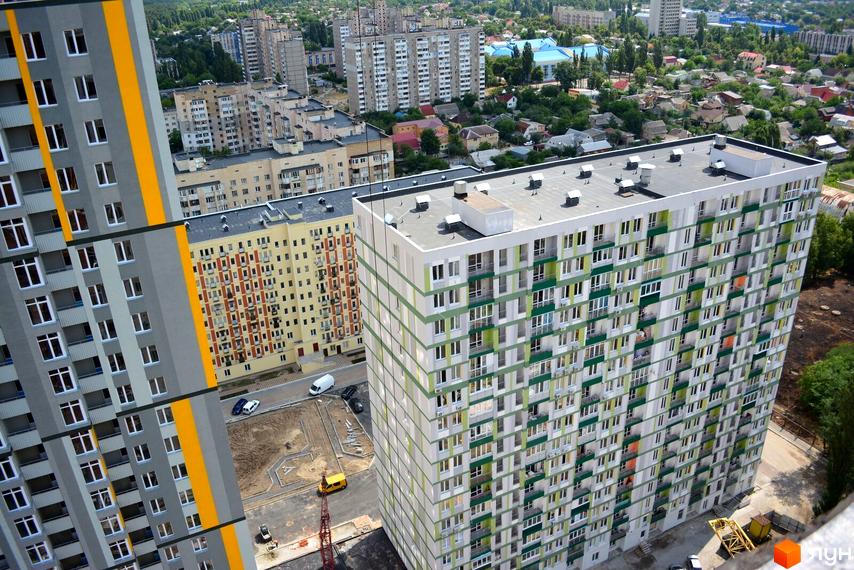 Житловий комплекс Грюнвальд з сучасними фасадами. Прибудинкова територія з паркувальними місцями та зеленими насадженнями.