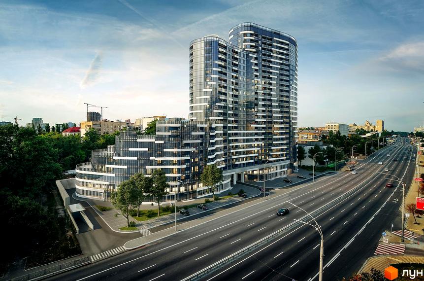 Житловий комплекс Aria – це сучасна новобудова з панорамним склінням та балконами, розташована вздовж широкої дороги з автомобілями та зеленими насадженнями.