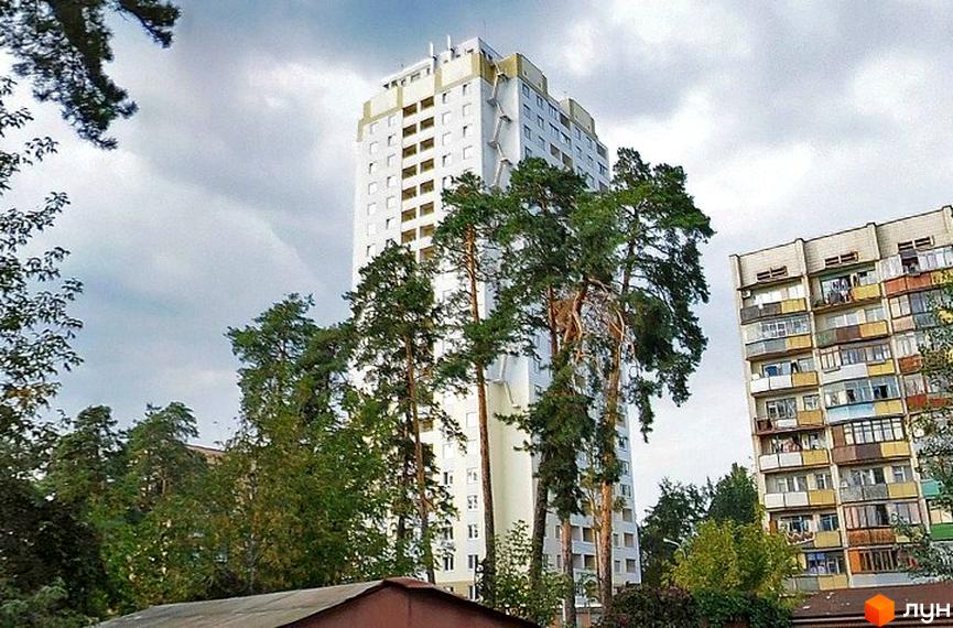 Висотний будинок на вул. Поліська, 28б, оточений зеленими насадженнями та прибудинковою територією.