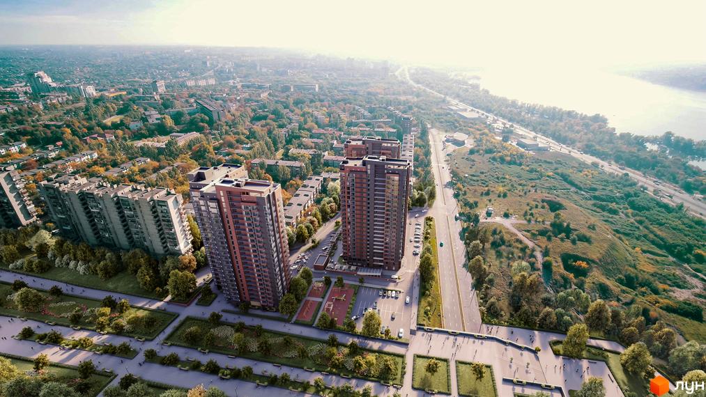Високі будинки ЖК Central з фасадами у коричневих тонах, поруч з парком та дорогою. На території є дитячий майданчик та парковка.