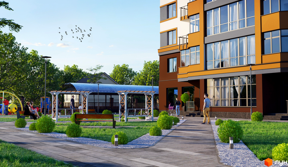 Зображення фасаду та прибудинкової території Житлового комплексу Капітал 2. Вигляд новобудови з тротуаром, газоном та місцем для відпочинку.