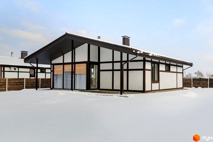 Будинок у Котеджному містечку Удачино з білим фасадом та темними балками, розташований на засніженій ділянці.